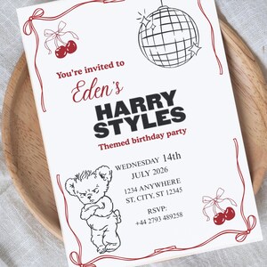 May include: A white invitation card with red decorative elements. The text reads "You're invited to Eden's Harry Styles Themed birthday party." Includes a cartoon bear, cherries, and a disco ball. The date is Wednesday, 14th July 2026.