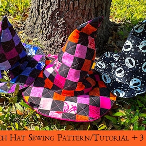 Può includere: Tre cappelli da strega fatti a mano in vari colori e motivi. Uno è nero con stelle e lune bianche, un altro è rosa, arancione e nero a scacchi, e il terzo è blu, viola e nero a scacchi. I cappelli sono sull'erba verde.