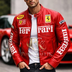 May include: Red leather jacket with white "Ferrari" lettering and logos. The jacket has a round collar and is worn over a white t-shirt. The sleeves have the word "Ferrari" printed on them. The jacket is worn with black jeans.