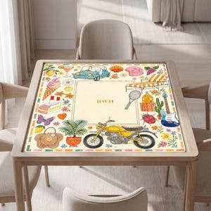 K&ouml;nnte beinhalten: Eine quadratische Tischmatte mit cremefarbenem Zentrum und den Buchstaben RWH. Der Rand zeigt bunte Illustrationen, darunter ein blaues Auto, ein gelbes Motorrad, eine Gitarre, ein Liegestuhl, eine Topfpflanze, ein Schmetterling und diverse Snacks.