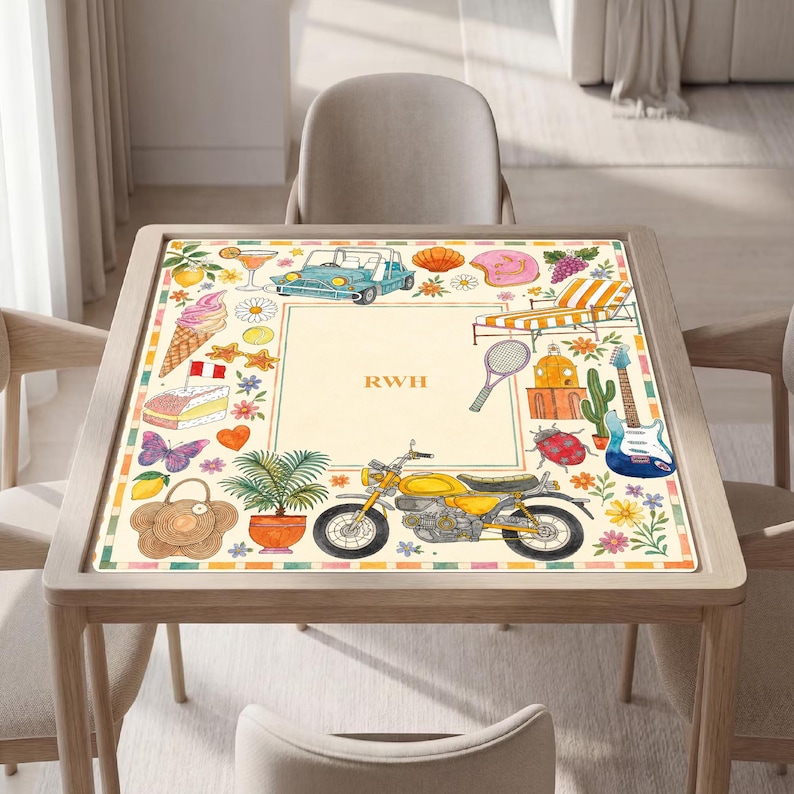 K&ouml;nnte beinhalten: Eine quadratische Tischmatte mit cremefarbenem Zentrum und den Buchstaben RWH. Der Rand zeigt bunte Illustrationen, darunter ein blaues Auto, ein gelbes Motorrad, eine Gitarre, ein Liegestuhl, eine Topfpflanze, ein Schmetterling und diverse Snacks.