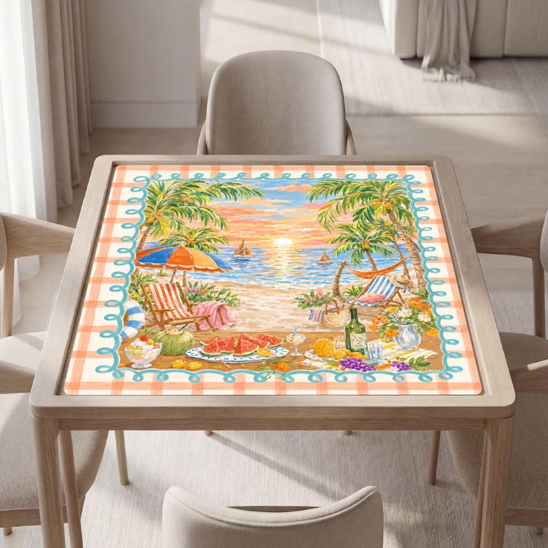 Op de afbeelding: Een vierkante placemat met een strandtafereel met palmbomen, een zonsondergang boven de oceaan, zeilboten, ligstoelen en een hangmat. Op de voorgrond staat een picknick met watermeloenpartjes, fruit en een fles, omlijst door een perzikkleurige ruitrand.