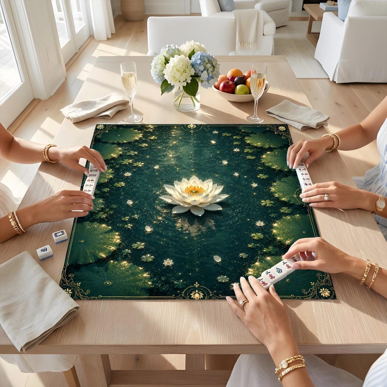 May include: A rectangular mahjong mat featuring a dark green pond surface with a central white lotus flower, surrounded by scattered lily pads and golden sparkles, with white mahjong tiles placed along the edges of the mat.