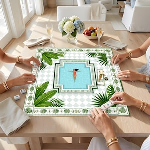 May include: A square mahjong mat featuring a central illustration of a person in a red swimsuit floating in a blue swimming pool, surrounded by a white and light blue checkered pattern and a border of green tropical palm leaves and foliage.