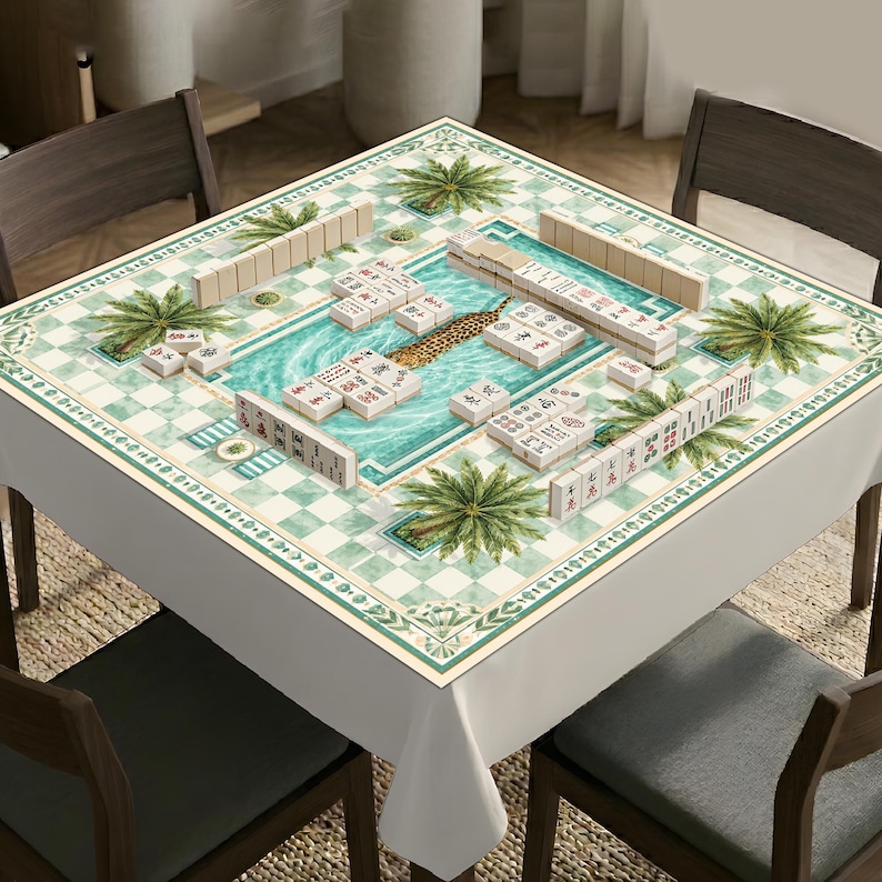 K&ouml;nnte beinhalten: Eine quadratische Mahjong-Tischdecke mit einem zentralen Motiv eines Swimmingpools mit einem Leopardenmuster-Schwimmtier, umgeben von einem gr&uuml;n-wei&szlig;en Karomuster mit Palmenillustrationen. Die Oberfl&auml;che ist mit elfenbeinfarbenen Mahjong-Steinen belegt.
