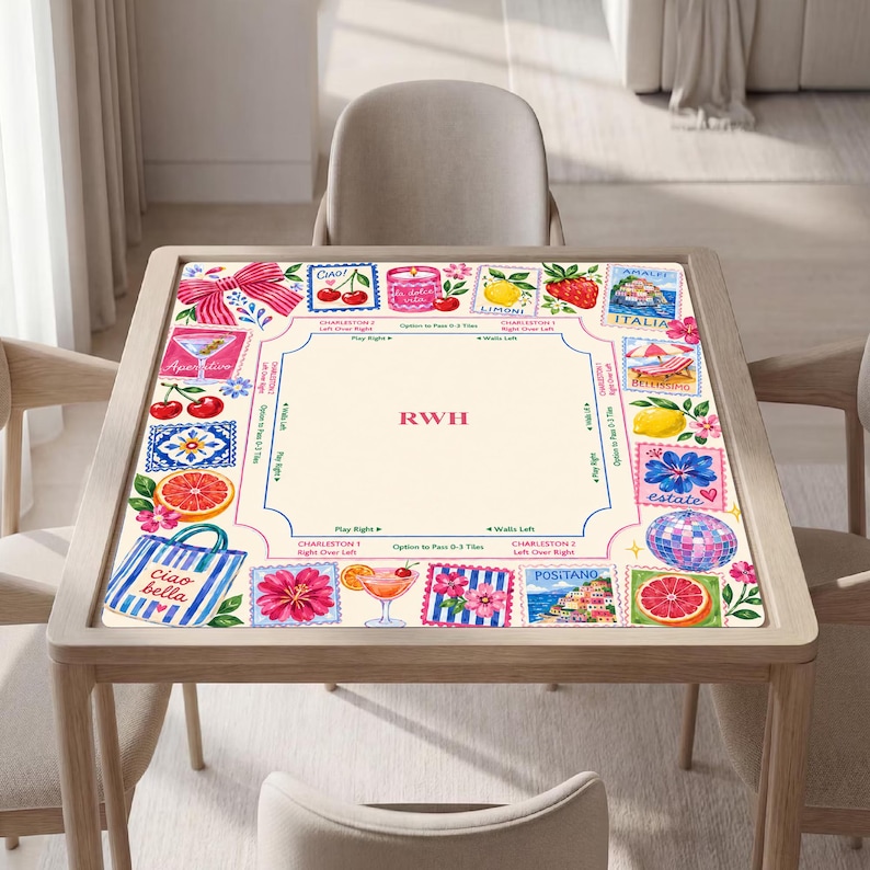 May include: A square mahjong mat featuring a cream-colored center with the letters RWH in red. The border displays colorful illustrations of cherries, lemons, grapefruit, cocktails, a beach bag, and Italian coastal scenes with text like Ciao bella.