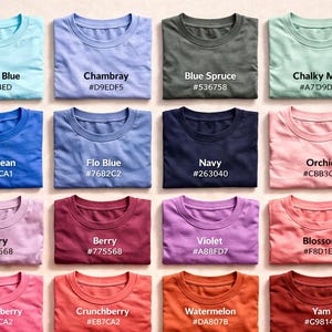 May include: A selection of folded t-shirts in a variety of colours, such as blue, green, pink, and purple. Each shirt displays a different colour name and a corresponding hex code. The shirts are neatly arranged, showcasing a range of hues.