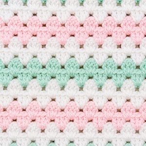 May include: A crocheted fabric featuring a repeating shell stitch pattern arranged in horizontal stripes. The design consists of alternating rows of soft pastel mint green, crisp white, and light baby pink yarn, creating a textured surface.