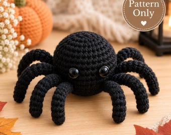 May include: A black crocheted spider toy with two large, glossy black eyes. The spider has a round body and eight curved legs. A circular badge in the upper right corner contains the text Pattern Only with a small heart icon below the text.