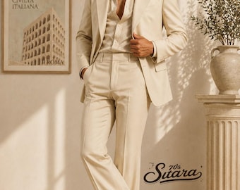 May include: A cream-colored suit with a matching shirt. The suit features a blazer and flared pants. The image includes a framed print of a building and the text "70s Sitara". The model is wearing brown leather shoes.