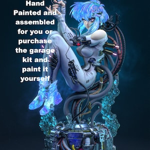 May include: A cybernetic figure with iridescent blue hair and a white bodysuit, holding a handgun. The figure is connected to a complex mechanical base with tubes and wires. Text reads: Hand Painted and assembled for you or purchase the garage kit and paint it yourself.