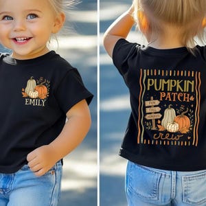 May include: A black short-sleeve t-shirt featuring a small graphic of pumpkins and the name EMILY on the front left chest. The back displays a large graphic with the text PUMPKIN PATCH, FUN, FALL, MEMORIES, and illustrations of pumpkins.