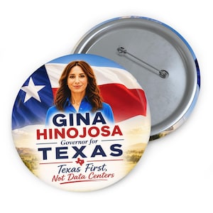 May include: A round pin-back button featuring a portrait of Gina Hinojosa in a blue shirt against a Texas flag background. Text reads: GINA HINOJOSA Governor for TEXAS, Texas First, Not Data Centers. The back shows a metal pin mechanism.