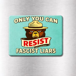 May include: Rectangular magnet with a teal background featuring a cartoon bear wearing a ranger hat. The text reads "ONLY YOU CAN RESIST FASCIST LIARS" in a vintage style font. The bear has a stern expression.