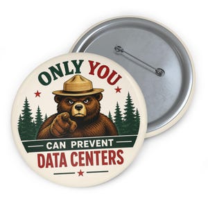May include: A round pin-back button featuring a brown bear wearing a tan ranger hat, pointing forward. The text reads ONLY YOU CAN PREVENT DATA CENTERS. The background shows dark green pine trees, red stars, and a cream-colored base with a metal pin back.