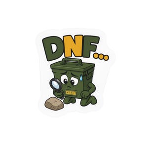 May include: A die-cut sticker featuring a cartoon olive green ammunition box with a sad face, holding a magnifying glass over a rock. The box has the word CACHE printed on it, and the text DNF... appears in large yellow and green letters above.
