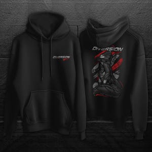 May include: Black hoodie with the word "DIVERSION" in red and white on the front and back. The back of the hoodie features a graphic of a figure in a black outfit with red accents. The hoodie has a hood and a front pocket.