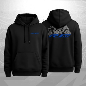 May include: A white ceramic mug with a black handle and the text "But First, Coffee" in a bold, black font. The mug is set against a neutral background, highlighting its simple design.