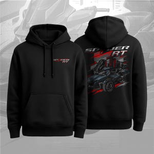 Puede incluir: Sudadera con capucha negra con bolsillo delantero y capucha con cordón. La parte delantera presenta el texto "SPYDER RT" en rojo y blanco. La parte trasera muestra un gráfico de un vehículo de tres ruedas negro y rojo con el texto "SPYDER RT".