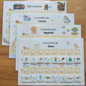May include: A set of four laminated routine charts for children, each featuring a unique theme like fire trucks, unicorns, lions, or flowers. Each chart includes a grid with columns for morning and evening tasks, featuring small velcro dots.