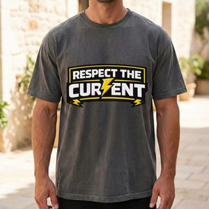 以下が含まれることがあります： 「Respect the Current」の文字が黄と白でデザインされた濃いグレーのTシャツ。クルーネックと半袖です。グラフィックには稲妻が含まれています。