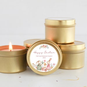 May include: Four gold candle tins with a white label featuring a floral design and two bunnies. The label reads "Happy Easter" with the text "The Macdonald Family 2023" below.