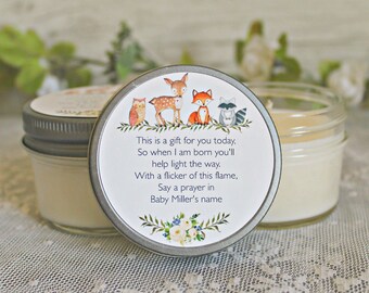 May include: A small glass jar candle with a silver lid. The lid has a woodland animal design with an owl, deer, fox, and raccoon. The text on the lid reads: "This is a gift for you today, So when I am born you'll help light the way. With a flicker of this flame, Say a prayer in Baby Miller's name"