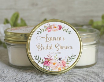 May include: Gold jar candle with a floral design label. The label says "Lauren's Bridal Shower 5.20.2018".