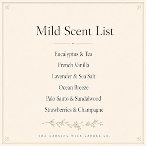 May include: A cream-colored rectangular sign with a thin border and floral corner accents. The text reads Mild Scent List followed by Eucalyptus & Tea, French Vanilla, Lavender & Sea Salt, Ocean Breeze, Palo Santo & Sandalwood, Strawberries & Champagne, and The Dancing Wick Candle Co.