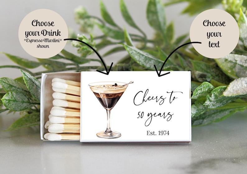 Puede incluir: Caja de cerillas blanca con una ilustraci&oacute;n en blanco y negro de un espresso martini. El texto en la caja de cerillas dice "Cheers to 50 years Est. 1974".