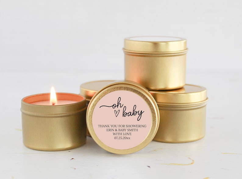 May include: Gold candle tins with a pink label that says "oh baby" with a heart. The label also says "Thank you for showering Erin & Baby Smith with love 07.25.20xx".