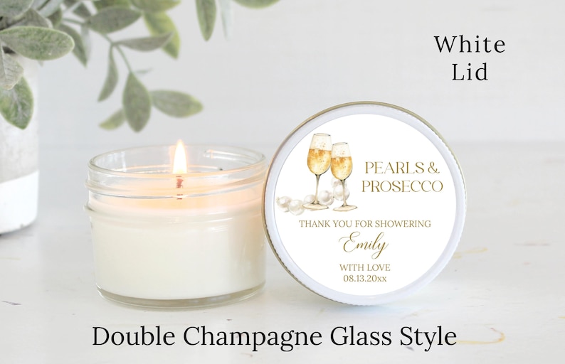 May include: A white candle jar with a white lid and a label that says "Pearls & Prosecco". The label also includes the text "Thank you for showering Emily with love 08.13.20xx". The label features a watercolor illustration of two champagne glasses.