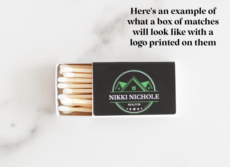 Pu&ograve; includere: Una scatola di fiammiferi con un'etichetta nera che presenta un logo di casa verde e il testo "NIKKI NICHOLE REALTOR *****".