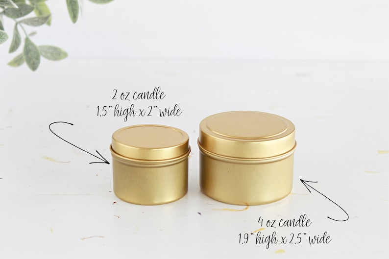 May include: Two gold metal candle tins. The smaller tin is 1.5 inches high and 2 inches wide and holds a 2 ounce candle. The larger tin is 1.9 inches high and 2.5 inches wide and holds a 4 ounce candle.