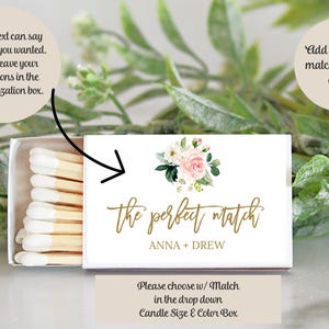 May include: A rectangular matchbox with a white cover featuring a floral illustration of pink and white roses, the gold script text the perfect match, and the names ANNA + DREW. The box is partially open, revealing wooden matches with white tips.