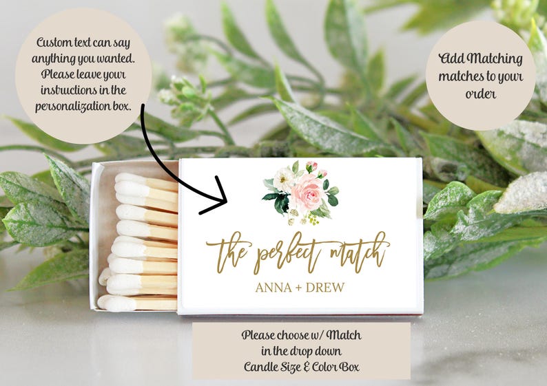 May include: A rectangular matchbox with a white cover featuring a floral illustration of pink and white roses, the gold script text the perfect match, and the names ANNA + DREW. The box is partially open, revealing wooden matches with white tips.