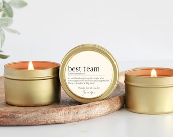 May include: Three gold candle tins with a white label. The label reads "best team (best-teem) noun an outstanding group of people who work together to achieve amazing results. They're kind of a big deal! Thanks for all you do! Jennifer"