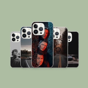 Może przedstawiać: Kolekcja pięciu etui na telefony z wizerunkami postaci i scen z serialu telewizyjnego. Etui prezentują różne wzory, w tym portrety, scenę drogową i symbol. Etui są w różnych kolorach.