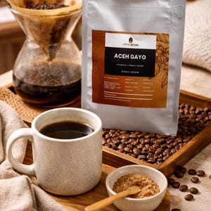 May include: A white ceramic mug with a black handle and the text "But First, Coffee" in a handwritten style. The mug is on a white surface. The mug is approximately 4 inches tall.