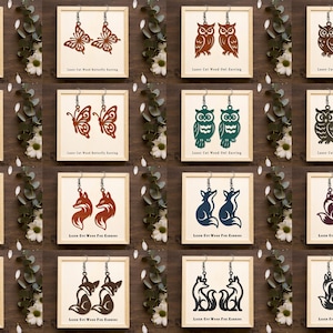 May include: A collection of sixteen pairs of laser-cut wooden earrings displayed on individual square cards. The designs feature butterflies, owls, and foxes in various colours including teal, brown, orange, blue, and black. Each card is labelled.