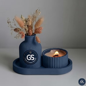 May include: A navy blue candle and vase set with dried flowers. The candle is lit, and the vase has a ribbed design. The set includes a tray with the logo "GS GLOBALSTOREBYSHAHZAD".