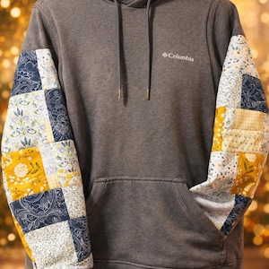 May include: A trio of ceramic mugs with a speckled, matte finish in cream, light grey, and dark grey. Each mug features a simple, minimalist design, ideal for tea or coffee.