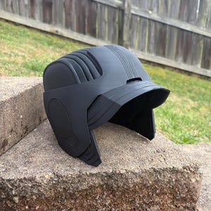 May include: A set of three ceramic mugs with a speckled, cream-colored glaze. Each mug features a different hand-painted floral design in shades of blue, green, and yellow. The mugs have a simple, rounded shape and a comfortable handle.