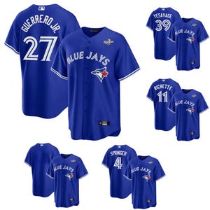 Może przedstawiać: Biały ceramiczny kubek z czarnym uchwytem i napisem "But First, Coffee" pogrubioną czcionką. Kubek jest umieszczony na rozmytym tle, sugerującym przytulne otoczenie.