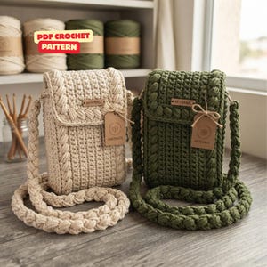 Può includere: Due borse a tracolla all'uncinetto, una color crema e una verde oliva, con motivo a punto testurizzato, tracolla intrecciata e patta rettangolare con etichetta marrone. La borsa crema ha un'etichetta HANDMADE e quella verde ARTISANAL. Il testo recita PDF CROCHET PATTERN.