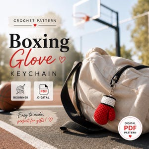 Op de afbeelding: Een rode en witte gehaakte bokshandschoen sleutelhanger hangt aan een beige sporttas. De afbeelding bevat de tekst "Boxing Glove Keychain" en "Crochet Pattern". Een basketbal en een basketbalring zijn op de achtergrond.