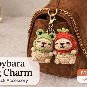 Può includere: Due ciondoli per borsa a forma di capibara all'uncinetto, uno con cappello da rana e l'altro con cappello da fragola, appesi a una borsa marrone. I ciondoli sono beige, verdi e rossi. Il testo recita "Capybara Bag Charm, Backpack Accessory".