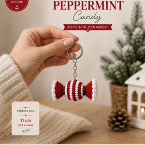 Può includere: Uno schema all'uncinetto per un portachiavi a forma di caramella alla menta. Il testo recita CROCHET PATTERN PEPPERMINT Candy KEYCHAIN ORNAMENT. La dimensione finita è di 11 cm. L'ornamento è una caramella a righe rosse e bianche.