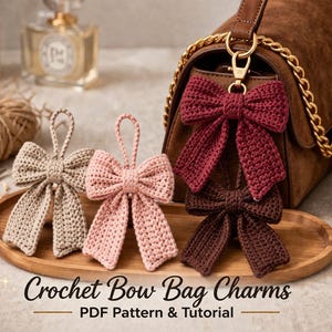 May include: Crochet bow bag charms in beige, pink, and burgundy, displayed on a wooden tray. Two charms hang from a brown purse. The image includes text that reads "Crochet Bow Bag Charms PDF Pattern & Tutorial."
