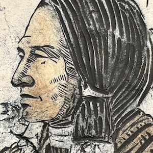 May include: A relief sculpture depicting a profile of a person with long hair and a detailed face. The artwork is primarily in shades of black, white, and tan, with textured details. The subject's hair is dark, and the skin is light.